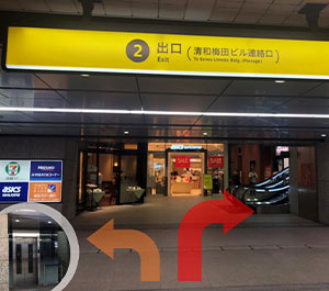 北東改札出て左、または北西改札出て右へ進み、2番出口のエレベーターかエスカレーターで地上へ